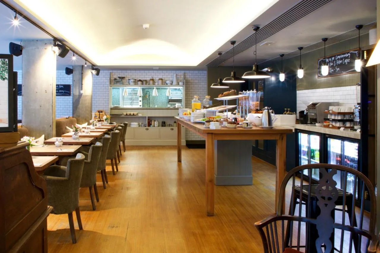 a restaurant with long tables and chairs in a room at Bermondsey Square Hotel - A Bespoke Hotel in London